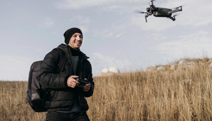 Man flying drone in open field